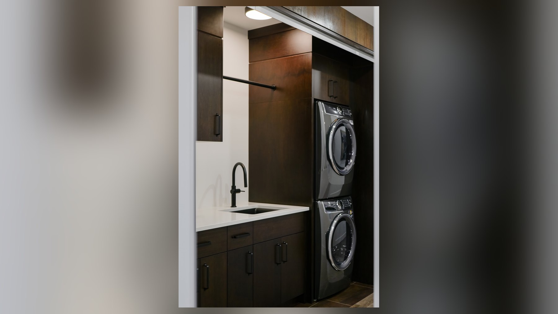 Custom millwork laundry with stacked washer and dryer